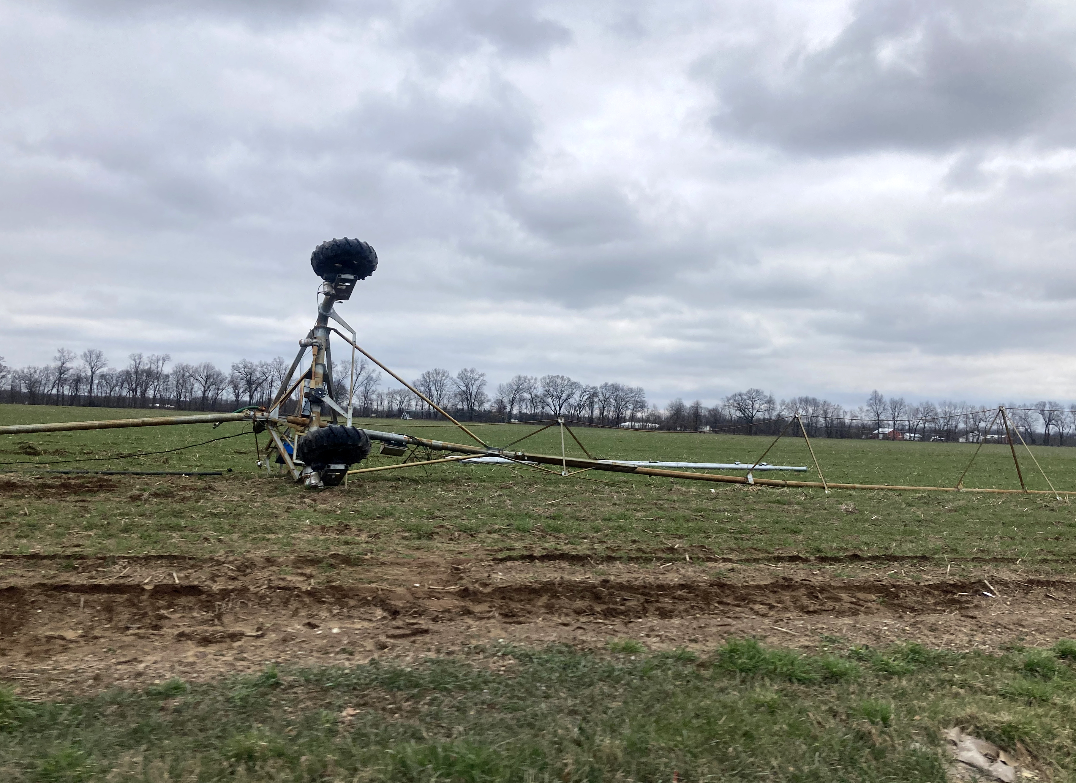 A flipped over center pivot irrigation system in a field.